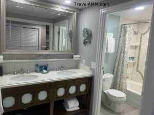 Beach Club bathroom area with double sinks, separate shower and toilet area