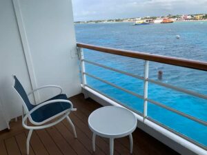Outside seating area in a balcony stateroom on the Disney Magic
